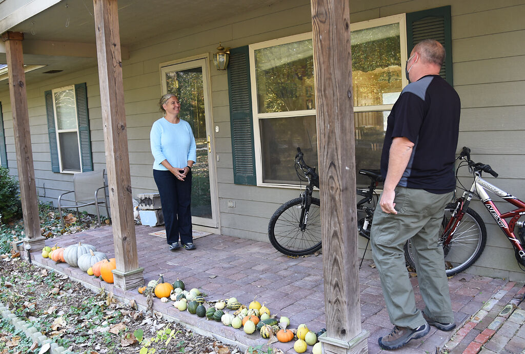 Adrian Plank, right, knocks on resident Julie Mitchell's door as a part of his preparation for the election on Saturday in Columbia.